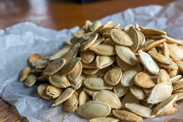 Grilled Pumpkin seeds with sea salt and spices on the wooden background