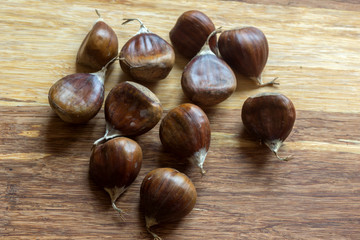 Roasted edible sweet chestnuts on brown wooden table