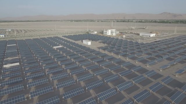 Backtracking drone shot over solar panel fields in remote part of China