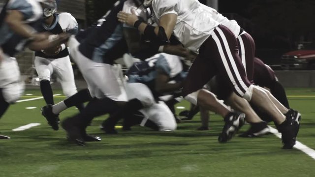 A football player jumps over the line and scores a touchdown