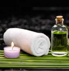 Obraz na płótnie Canvas tranquil spa scene- towel with black stones with candle ,green plant