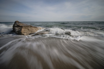 Waves crash into rocks on the beach