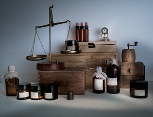 alchemy lab. bottles, jars, scales, clock on wooden shelves