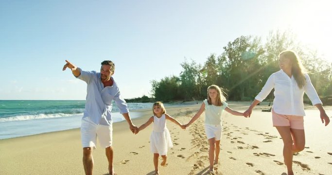 Happy mixed race family enjoying morning walk on the beach