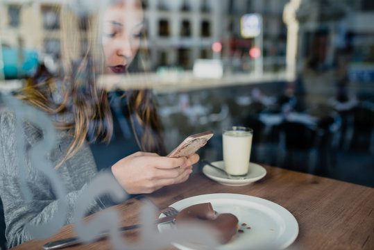 Girl using smartphone in beanery.