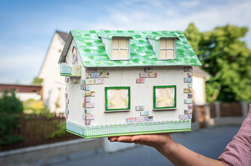 Real estate agent holding model house from paper