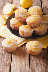Breakfast muffins with lemon zest and icing closeup on a plate. vertical