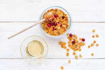 flakes in bowl with berries on wooden background top view