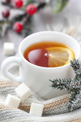 Cup of hot tea with lemon and woolen scarf