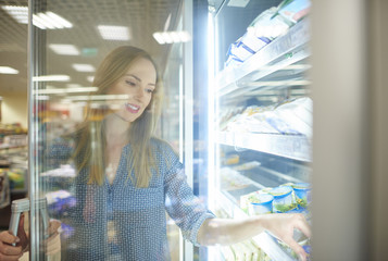 Female shopper reaching product from freezer