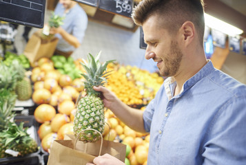 Young man buying fresh and healthy fruit .