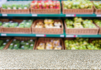 Marble empty table in front of blurred supermarket fruits shelf