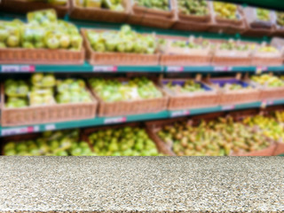 Marble empty table in front of blurred supermarket fruits shelf