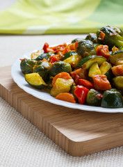 Fried vegetables on white plate and wooden desk