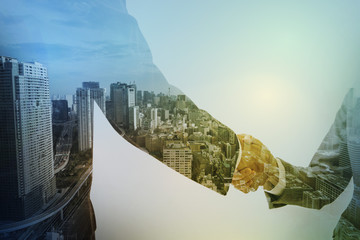 Double exposure of two business persons shaking hands and modern cityscape, relationship conceptual abstract - obrazy, fototapety, plakaty