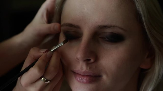 Make-up artist applying makeup to the model