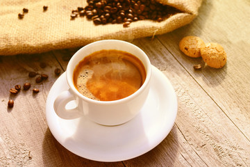 Cup of hot coffee on wooden surface