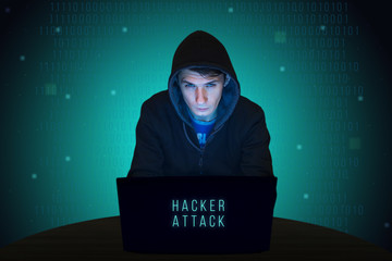 Hacker with laptop initiating cyber attack