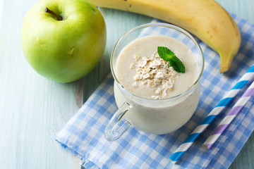 Apple banana smoothies with oatmeal on a light background. Healthy breakfast. Selective focus.