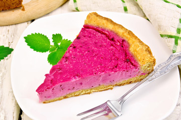 Pie of black currants with mint in plate on board