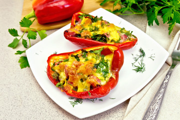 Pepper stuffed with sausage and cheese in white plate on granite