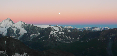 sunrise in the Swiss Alps with a full moon