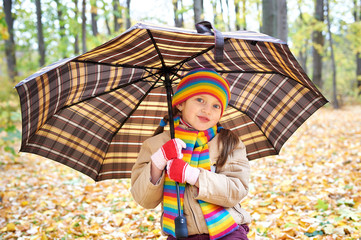girl child in autumn forest with umbrella, beautiful landscape in fall season with yellow leaves