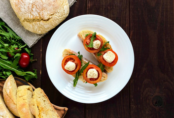 Bruschetta with arugula, tomatoes, mozzarella, olive oil on slices of chiabatta. Light breakfast. The top view