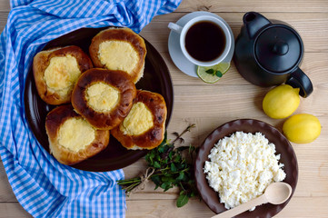Vanilla cottage cheese buns (cheesecake) cup of lemon tea. The top view.