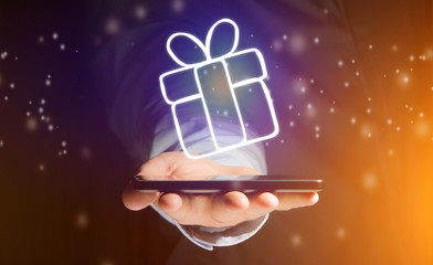 View of a Hand of a man holding smartphone with christmas icons all around