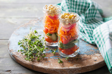 vegetable germinated lentil salad in a jar on a board, selective focus