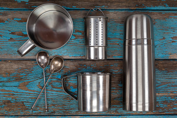 Metal thermos, strainer, mugs and spoons.