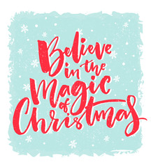 Christmas card design. Believe in the magic of Christmas. Inspirational xmas quote. Red brush calligraphy text on blue background with snowflakes.