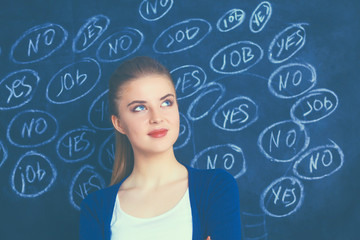 Young woman is standing on blackboard background and thinking: yes or no