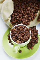 Green cup and saucer with coffee crop