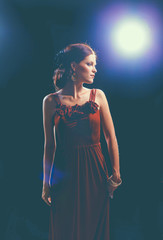 Young woman wearing a red dress standing