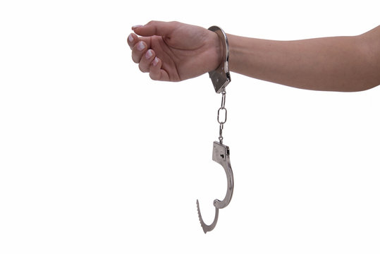 Mano di donna con manette su fondo bianco
