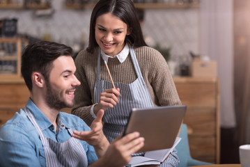 Delighted young couple making notes and using tablet.