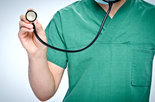 The Doctor In Green Scrubs Holding A Black  Pediatric Stethoscope.