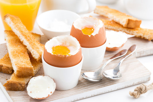 boiled eggs and toasts on a wooden board