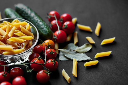 Still life with pasta, cherry tomatoes and cucumbers. The texture of pasta. Vegetables. Italian Pasta. Place for your advertising.