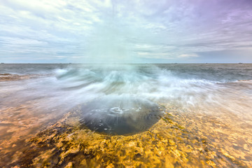 Wonderful Seascape with high waves hit large boulders create great water column represent the power of nature when high tides. It's great to watch the sea moments