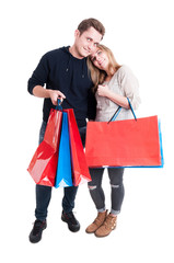 Happy couple standing and holding bunch of shopping bags