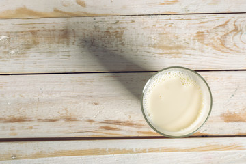 Glass of milk on table on blurred natural background