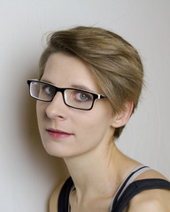 Portrait einer jungen Frau mit kurzen blonden Haare und Brille