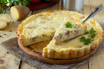 A classic quiche Lorraine pie with potatoes, meat and cheese on