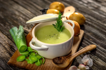 Homemade creamy leek soup on wooden background