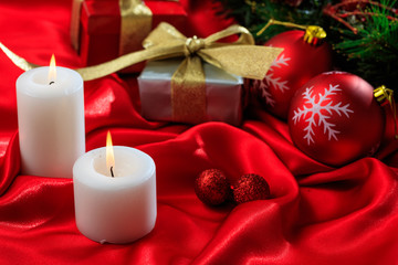 Gift boxes and candles on red satin