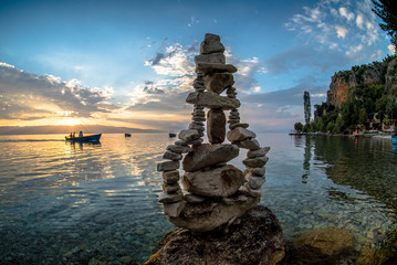 Pear like stone sculpture on sunset by the Ohrid lake - obrazy, fototapety, plakaty