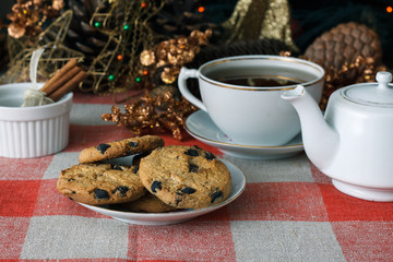 Homemade cookies in a plate on the feast of the new year, christmas. Tasty cookies on a table with a Christmas tree in the background. Tea.